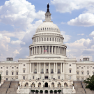 The United States Capitol Building against a blue sky peppered with clouds.